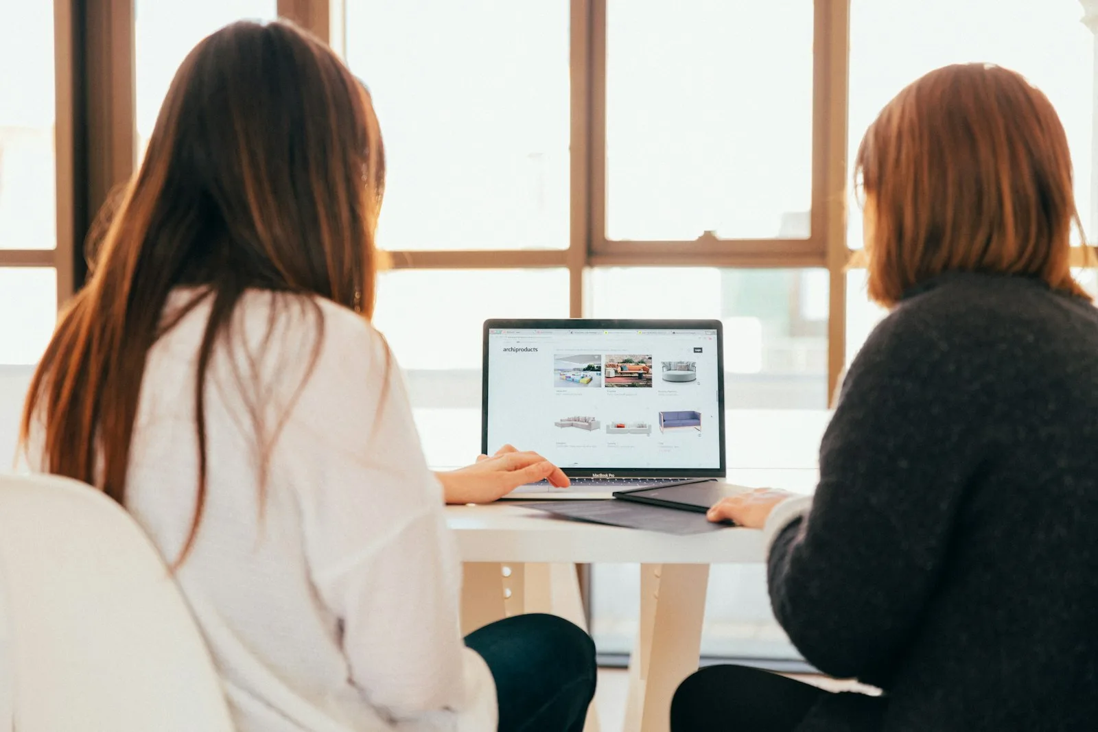 Zwei Personen besprechen eine Website am Laptop