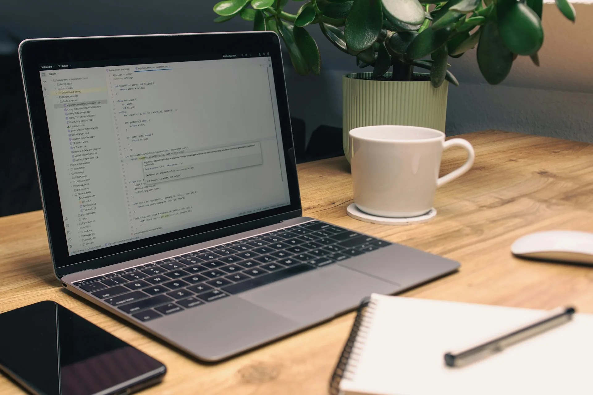 Schreibtisch mit Laptop, Notizbuch und Kaffeetasse